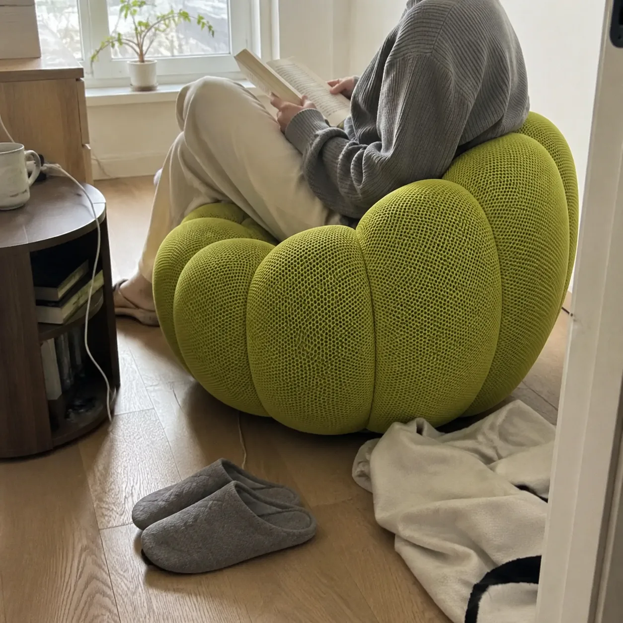 Green Bubble Floor Sofa used as a reading seat beside a window