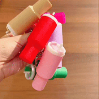 Colorful mini storage cups being clipped onto everyday bags
