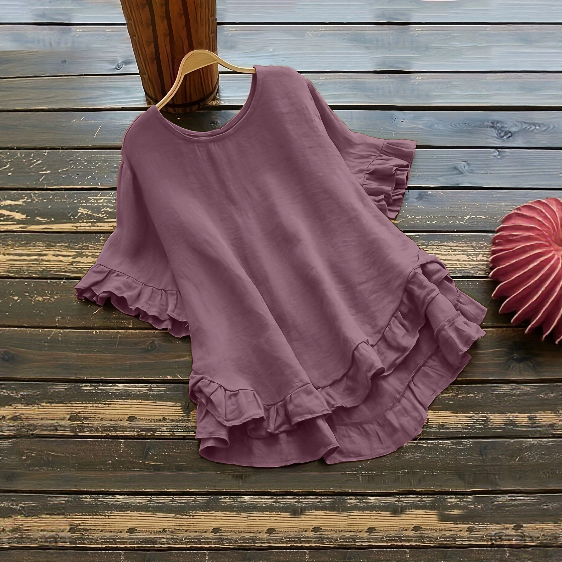 Buttonless ice silk ruffled hem top with front short and back long design, bell sleeves, and round neck