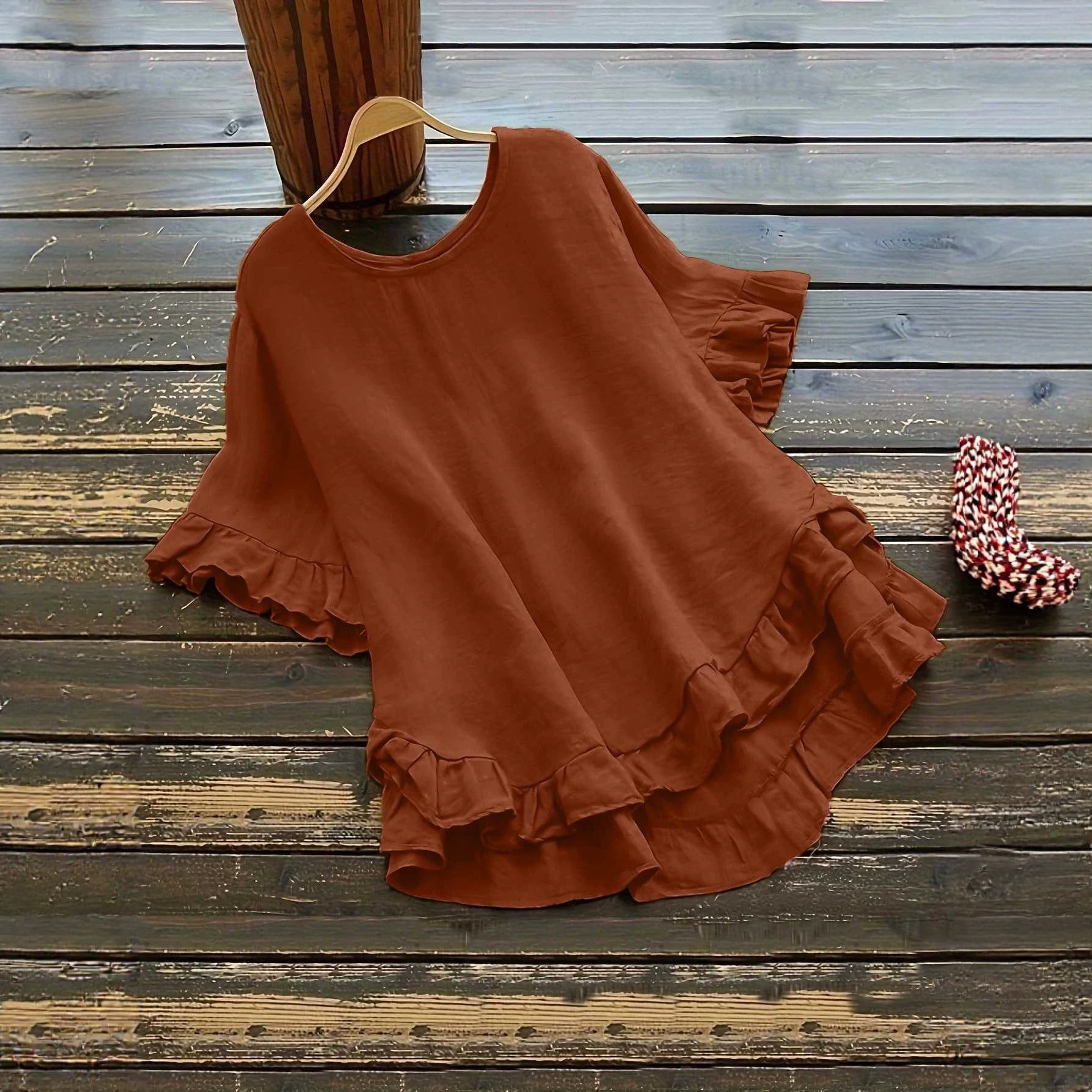 Buttonless ice silk ruffled hem top with front short and back long design, bell sleeves, and round neck