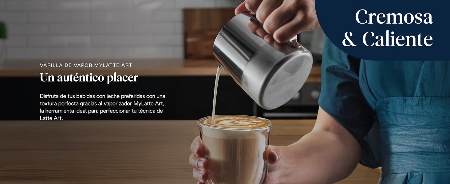 El texto dice «Cremosa &amp; Caliente». Escena de preparación de café en la que se ven manos vertiendo leche en una bebida oscura.