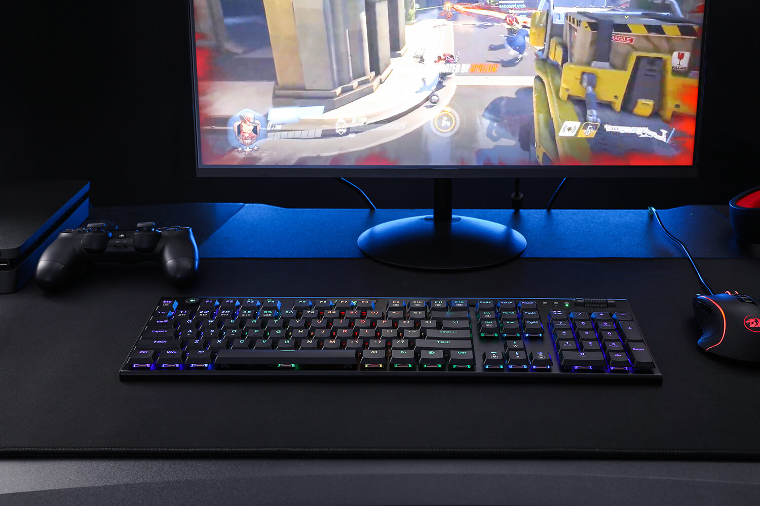 Redragon K618 wireless mechanical keyboard on a gaming desk setup, illuminated with vibrant RGB backlighting