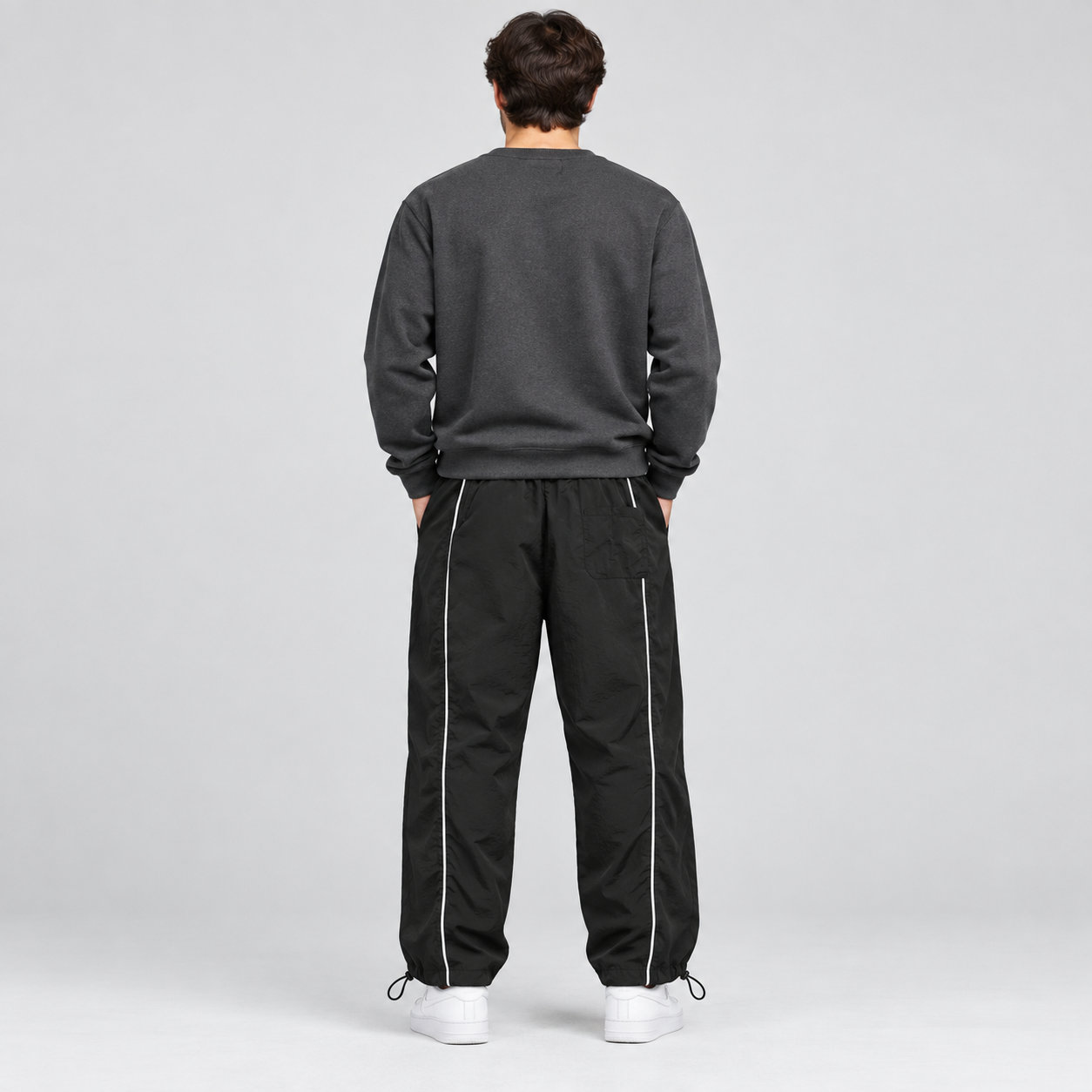 Men's black piped cinch-hem track pants back view