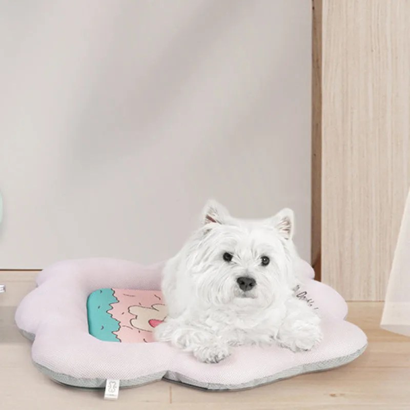 Green and pink pet cooling mats for dogs and cats in four different sizes on a wooden floor.