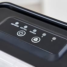 Close-up of a black control panel with illuminated touch-sensitive buttons, showing icons for power, water level, and other functions.