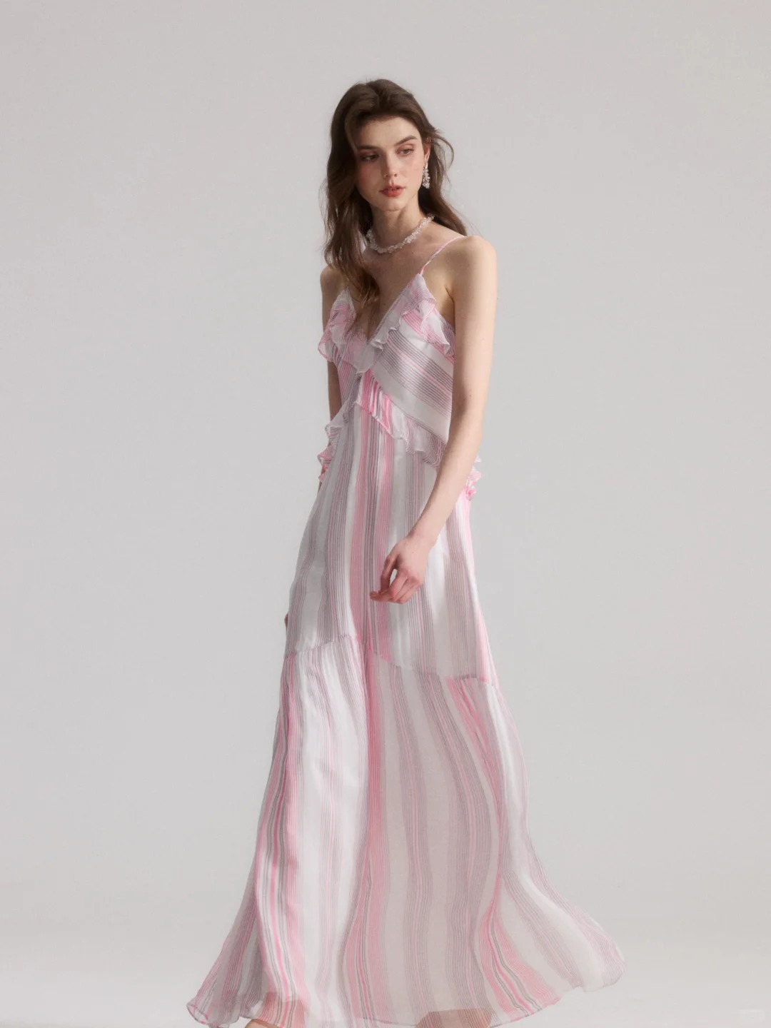 A French-style slip dress with pink and white stripes and ruffle details