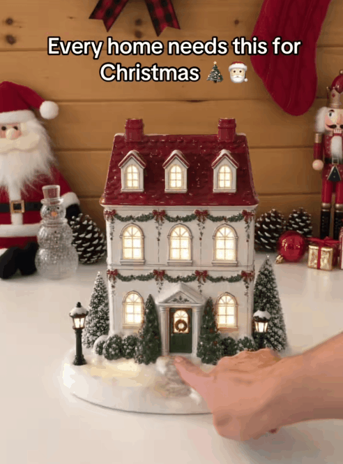 Christmas cottage diffuser glowing with mist from two chimneys