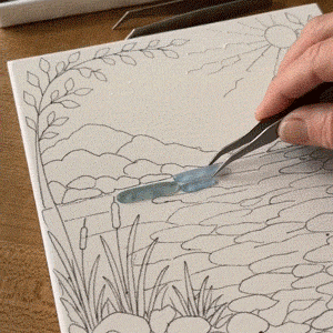 Placing sea glass pieces on the printed art base