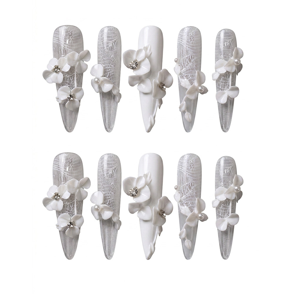 Glossy clear and solid white press-on nails with intricate white lace patterns, 3D sculpted flowers, pearls, and rhinestones.