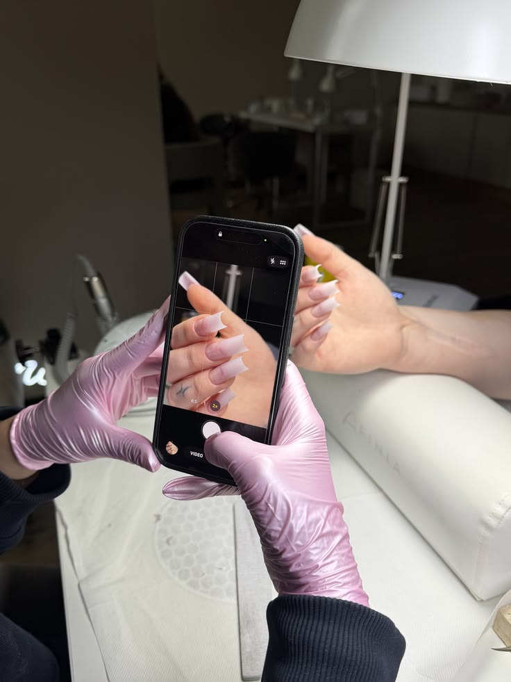 Nail artist taking photos of handmade custom press on nails inside minimalist nail art atelier, professional custom false nail workshop