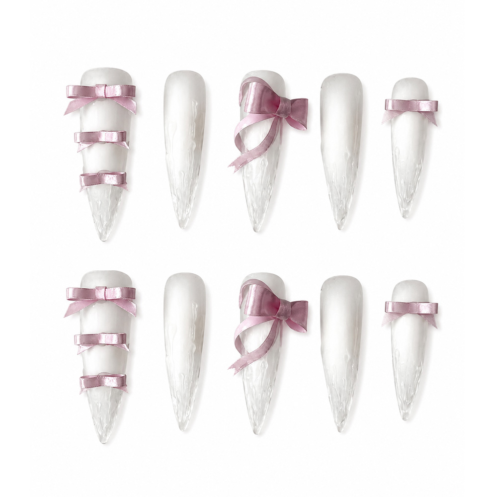 Frosted white stiletto press-on nails featuring realistic 3D melting icicle texture and dusty pink satin ribbon bows.