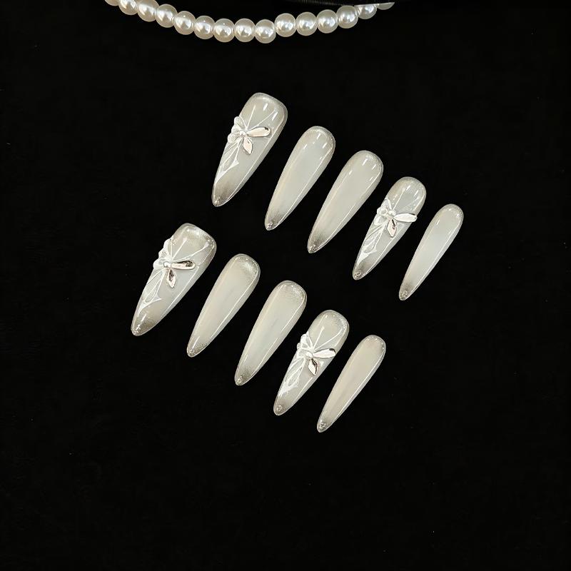 Translucent icy grey press-on nails with silver metallic 3D ribbons and delicate hand-drawn white lines.