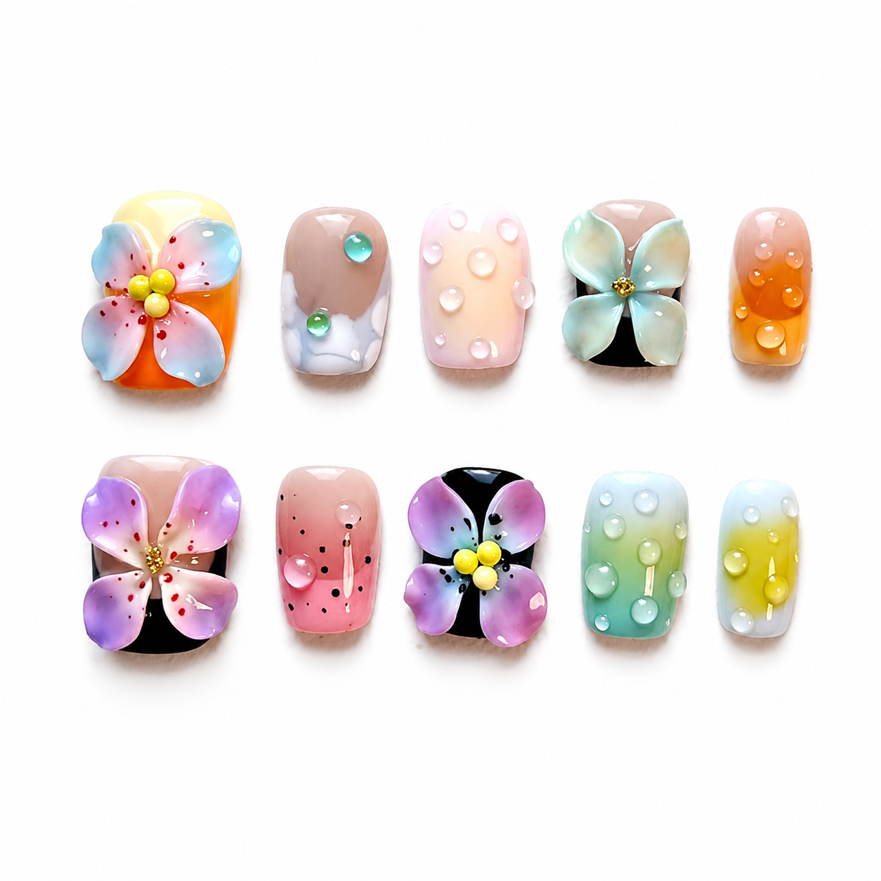 Glossy press-on nails with colorful sunset and teal gradients, hand-painted ink dots, large 3D sculpted flowers with gold beads, and 3D resin water droplets.