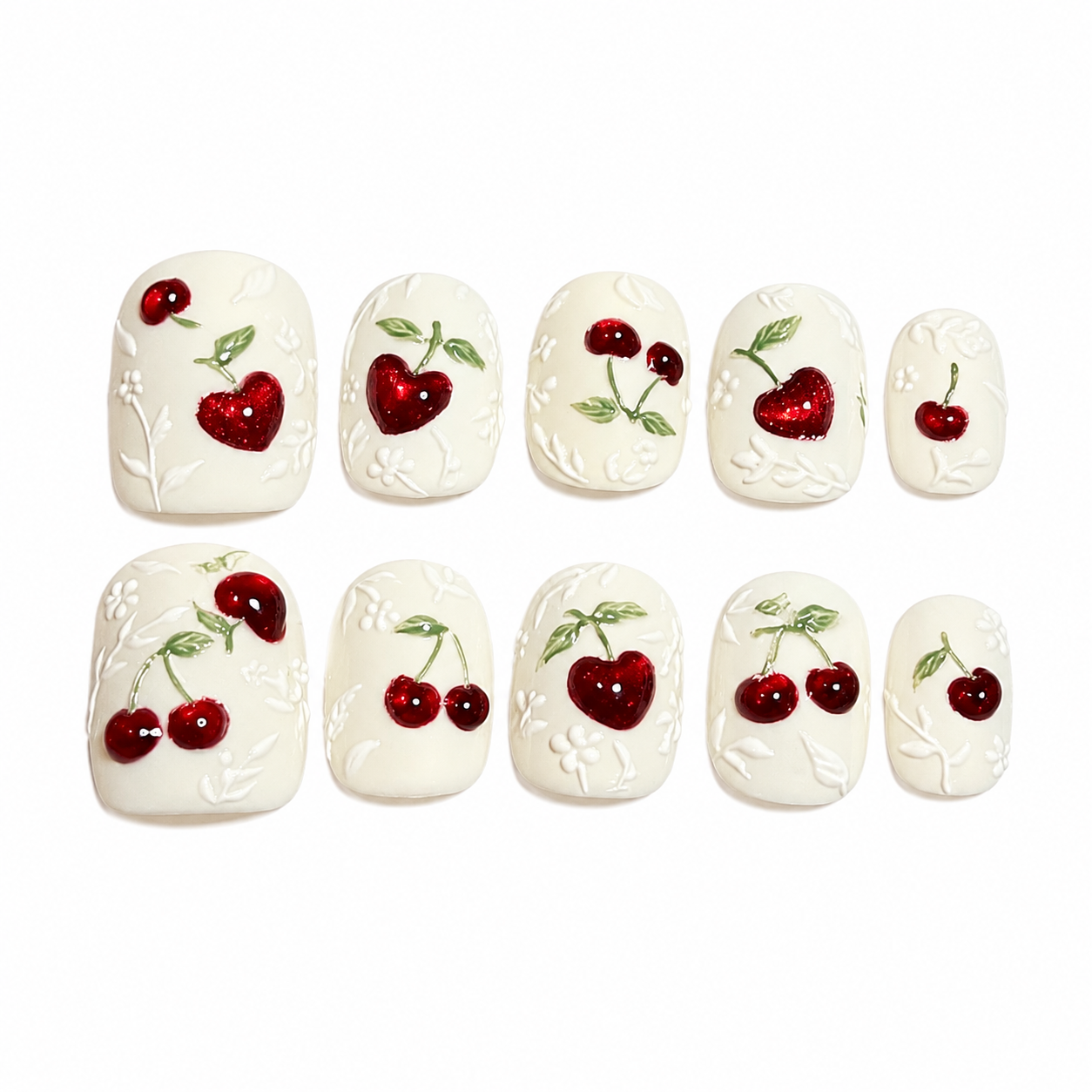 Glossy press-on nails featuring a matte white base with 3D embossed vines, hand-painted green leaves, and heart-shaped 3D red cat-eye cherry charms.