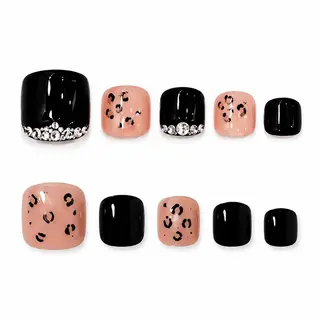 Asymmetric press-on toe nails featuring a solid black rhinestone-accented big toe on one foot and a nude leopard print big toe on the other