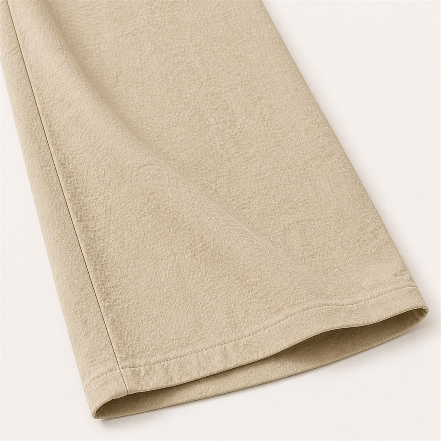 Large light-khaki lower-leg detail showing the crinkled surface, side seam and plain uncuffed hem