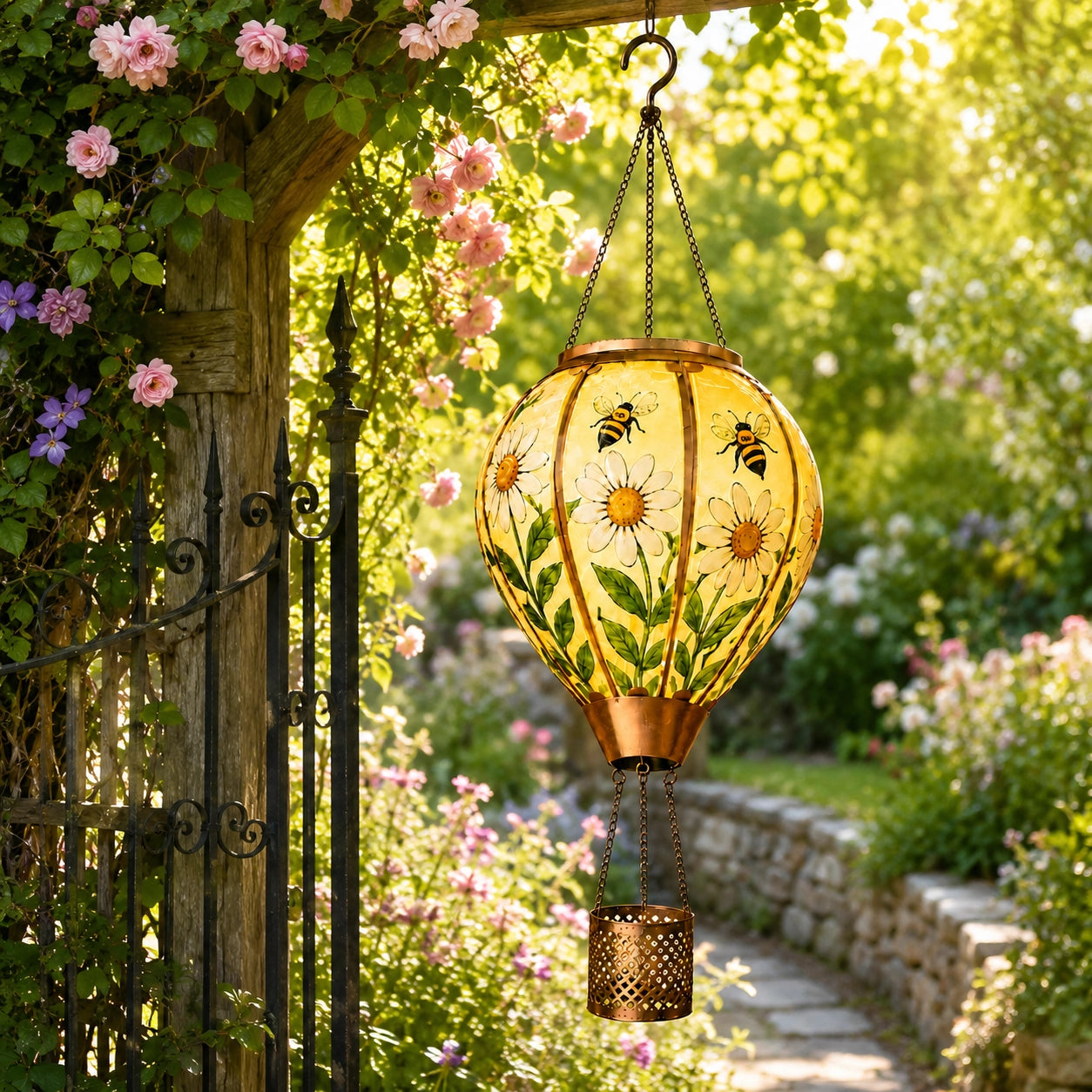 Bee and daisy hot air balloon solar lantern hanging beside a garden arbor and stone pathway