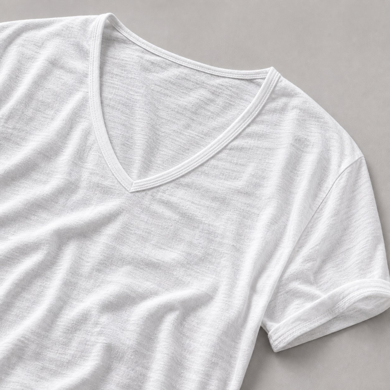 Close-up of white V-neck cotton T-shirt showing soft slub texture and neckline