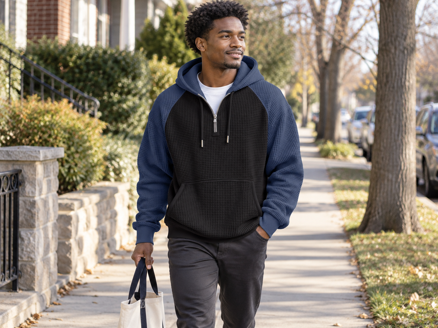 Man styling the black and blue colorblock waffle hoodie for an everyday walk