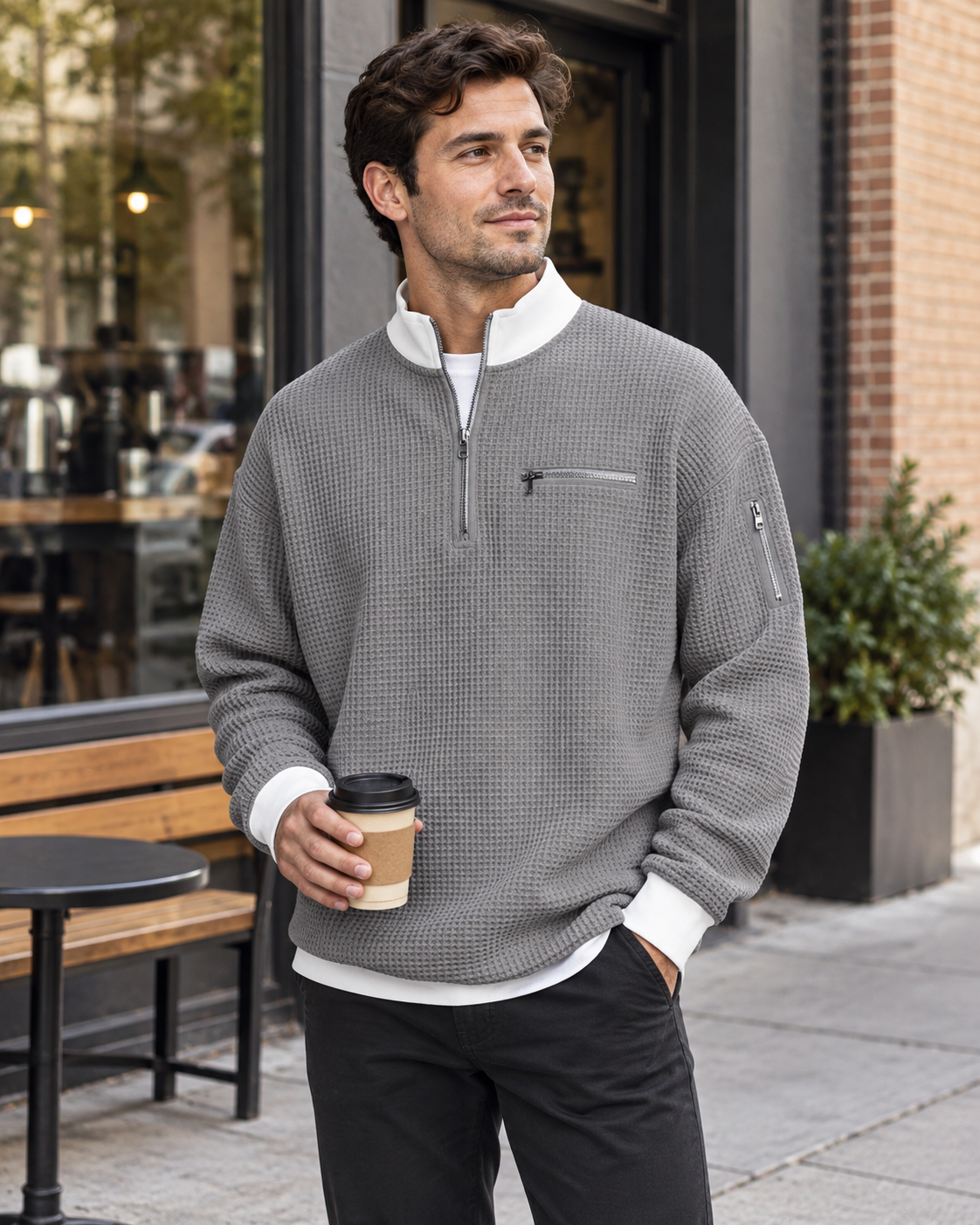 Man wearing the grey zip-up sports sweatshirt outside a café