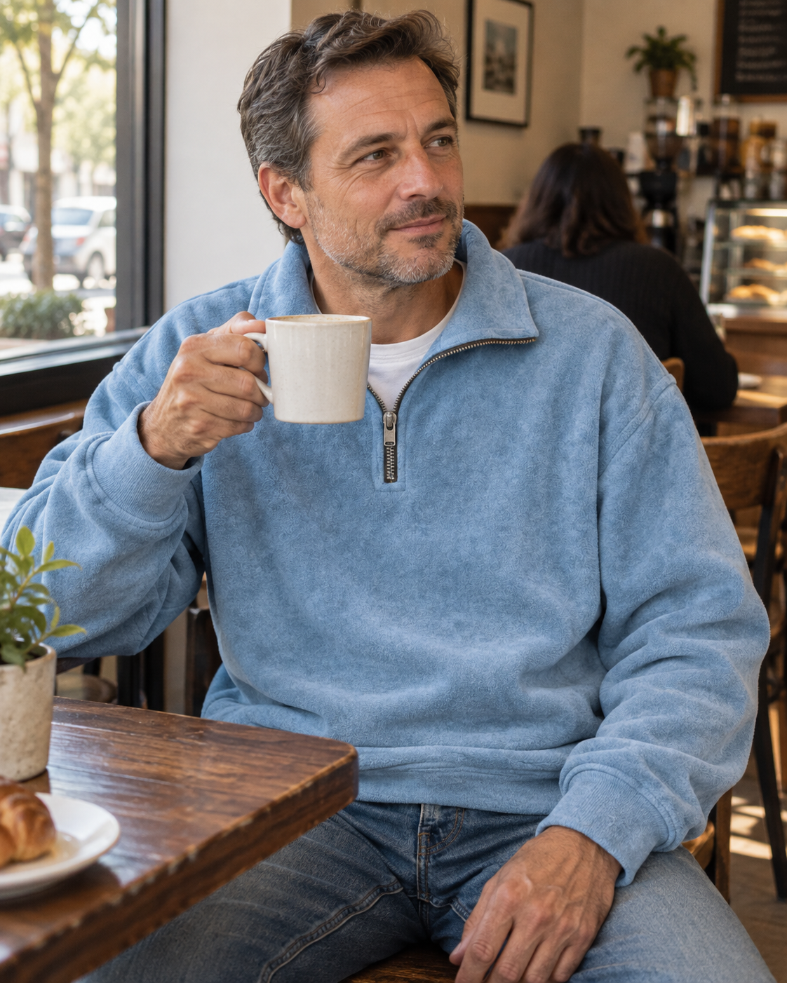 Light blue half-zip sweatshirt styled in a coffee shop