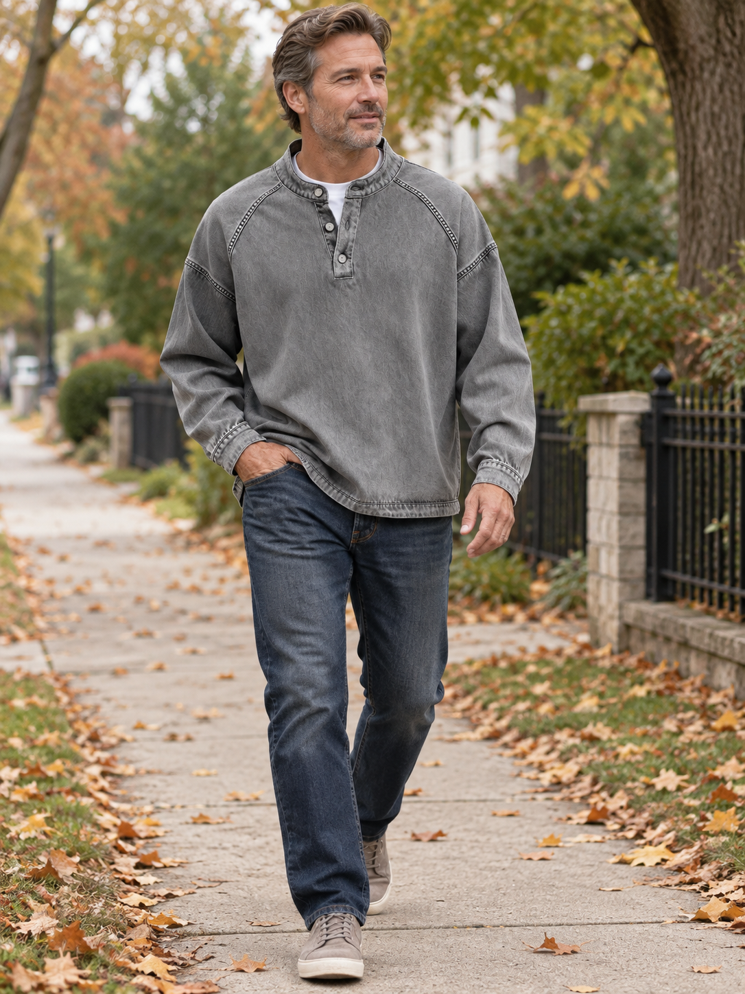 Mature man in a grey Henley shirt walking through a neighborhood