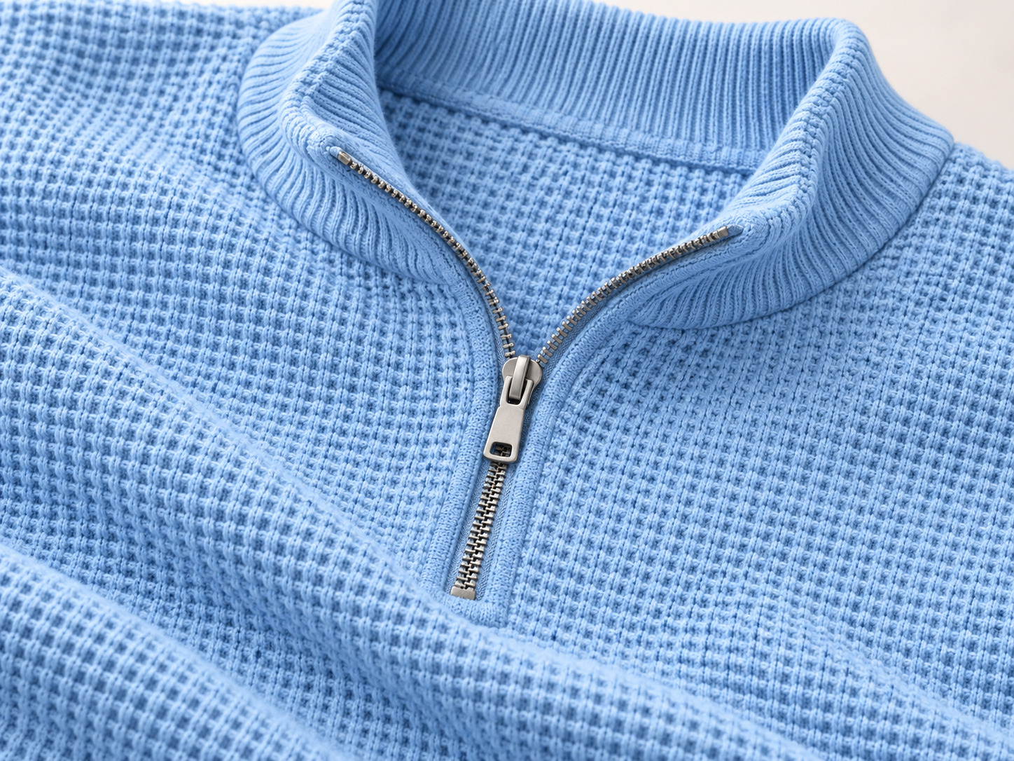 Illustrative close-up of the waffle knit and half-zip collar