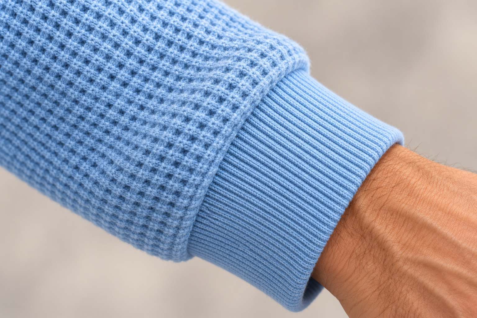 Illustrative close-up of the sleeve cuff and ribbed knit finish