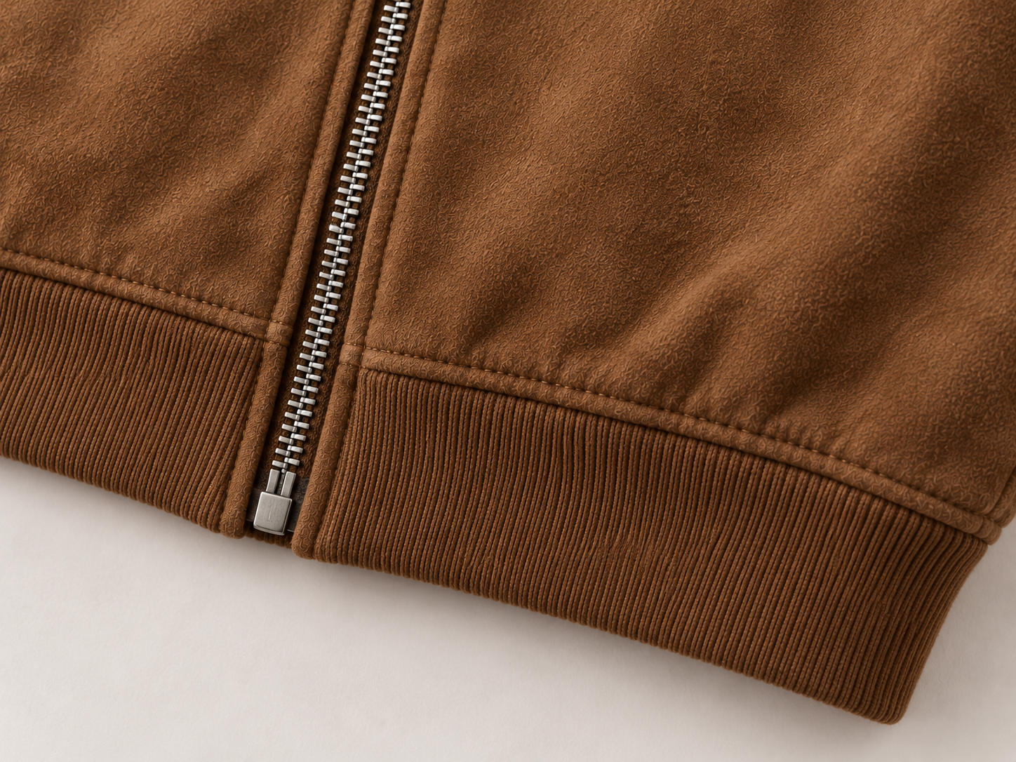 Close-up illustration of the rib-knit hem and lower zipper finish