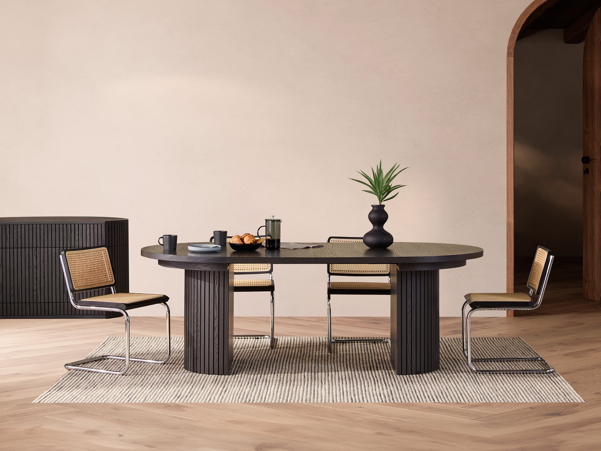 Versatile expandable dining table seats 4‑10, robust hardwood‑steel build, hidden pedestal storage and elegant fluted detailing for flexible everyday dining.