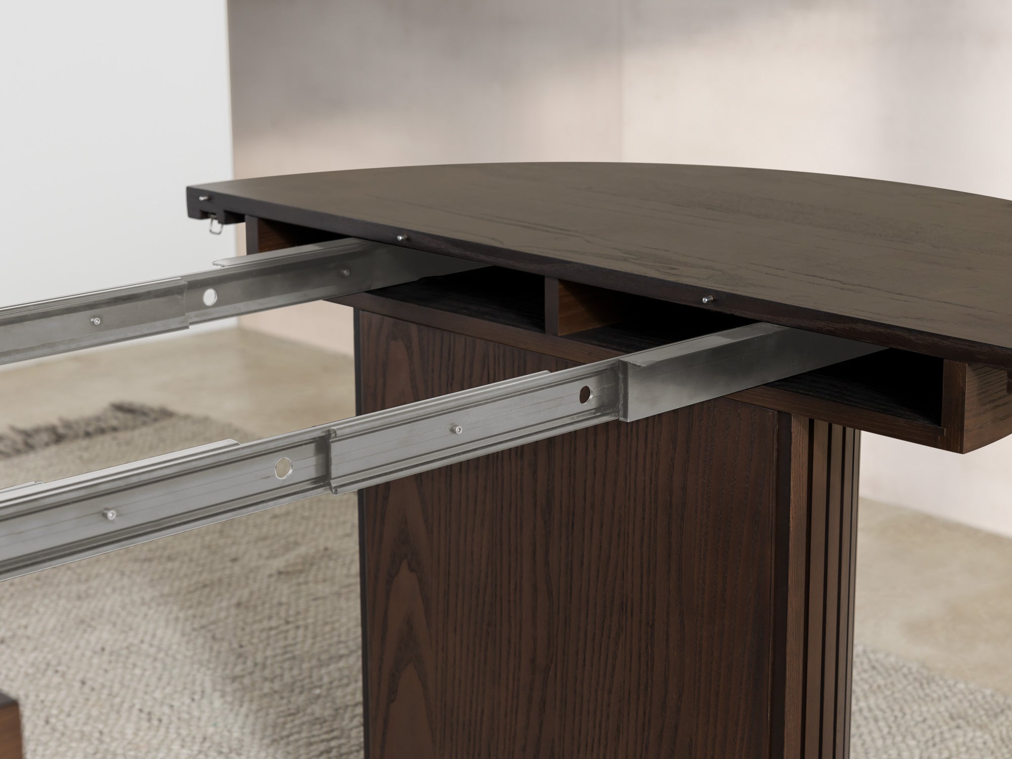 Versatile expandable dining table seats 4‑10, robust hardwood‑steel build, hidden pedestal storage and elegant fluted detailing for flexible everyday dining.