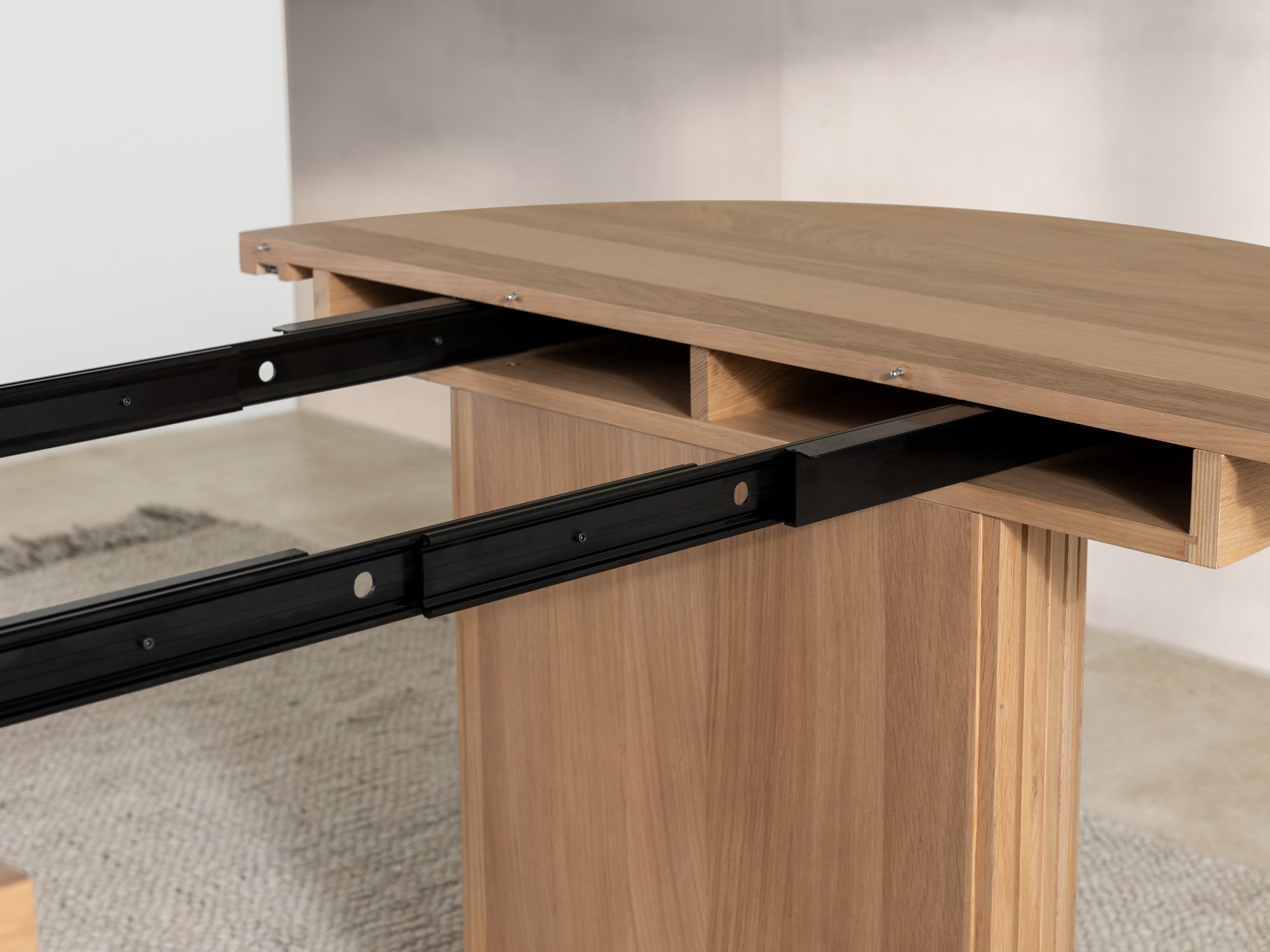Versatile expandable dining table seats 4‑10, robust hardwood‑steel build, hidden pedestal storage and elegant fluted detailing for flexible everyday dining.