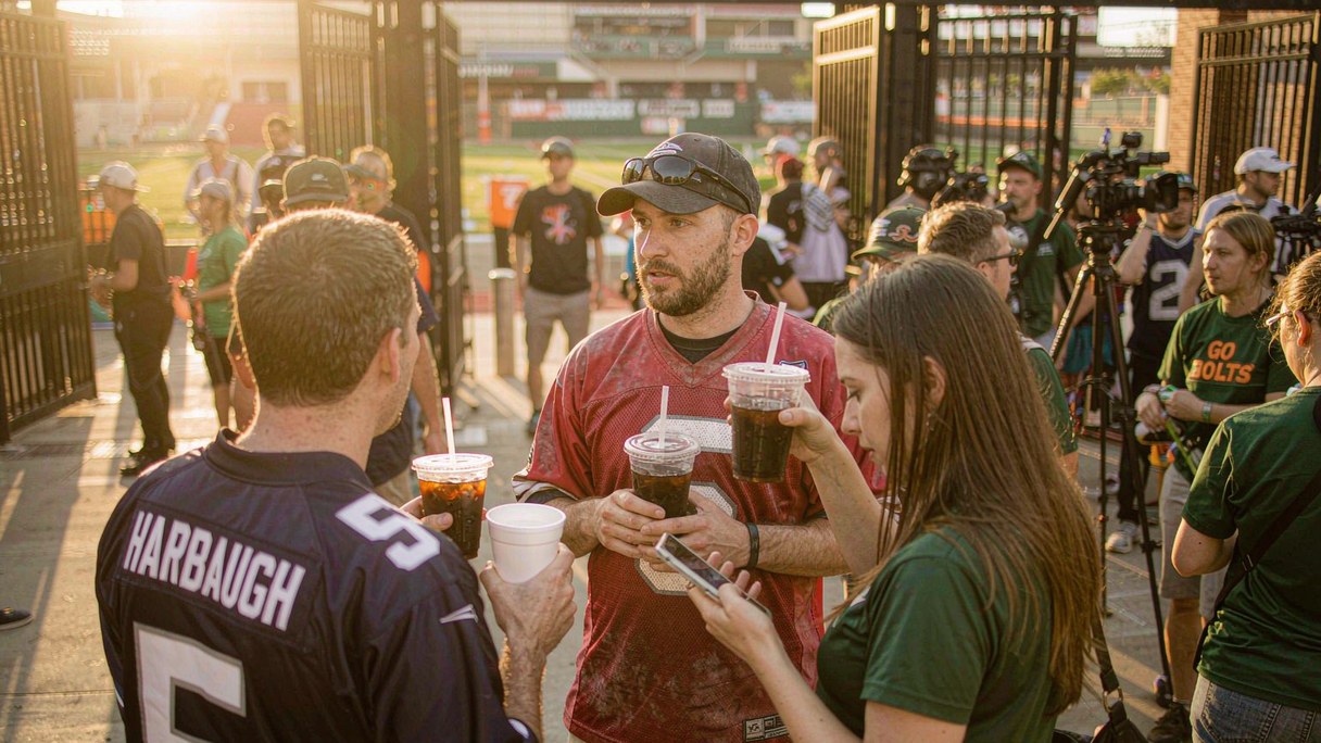 Football fans wearing team jerseys before an NFL Sunday kickoff