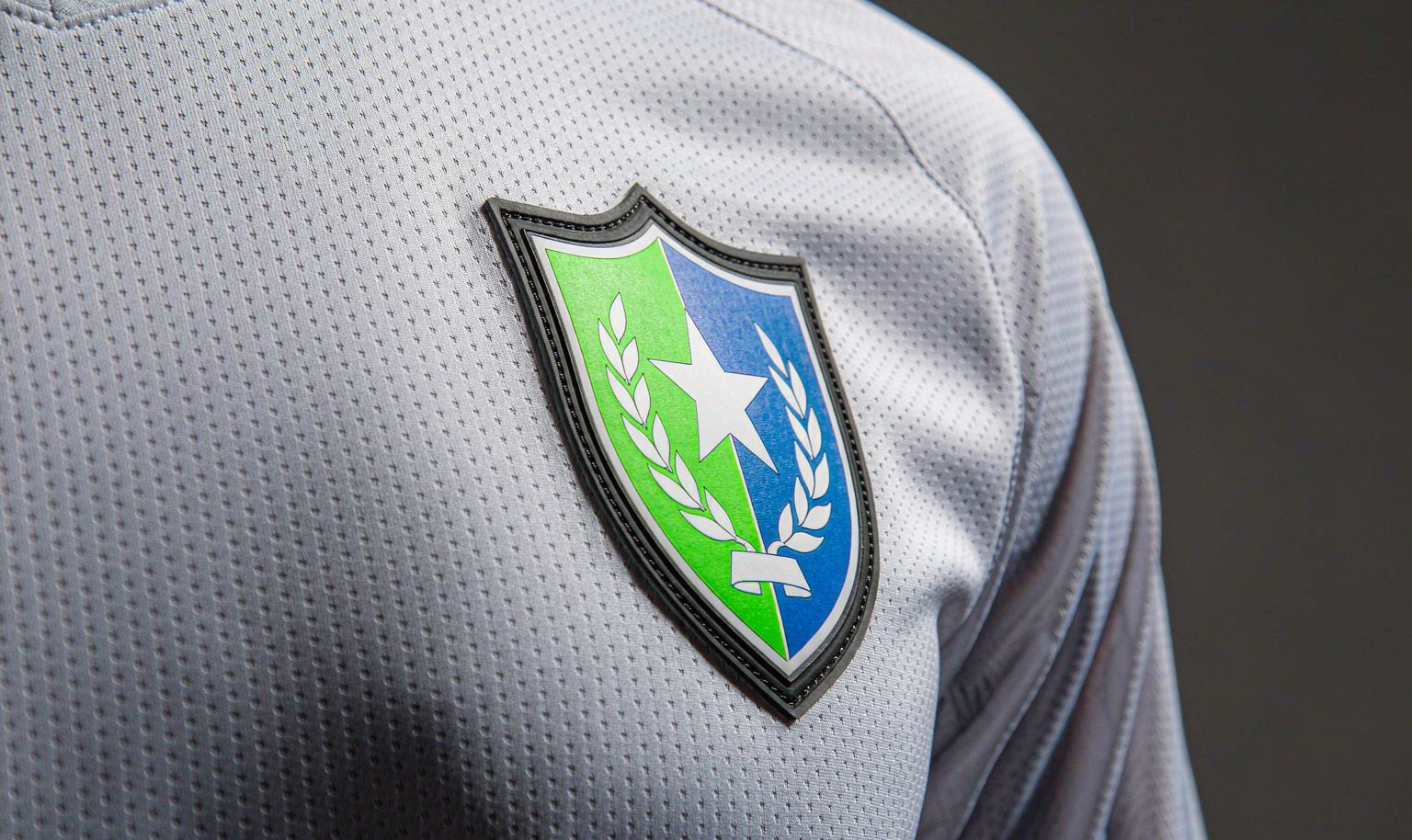 Heat-sealed club crest on a white soccer jersey - macro detail