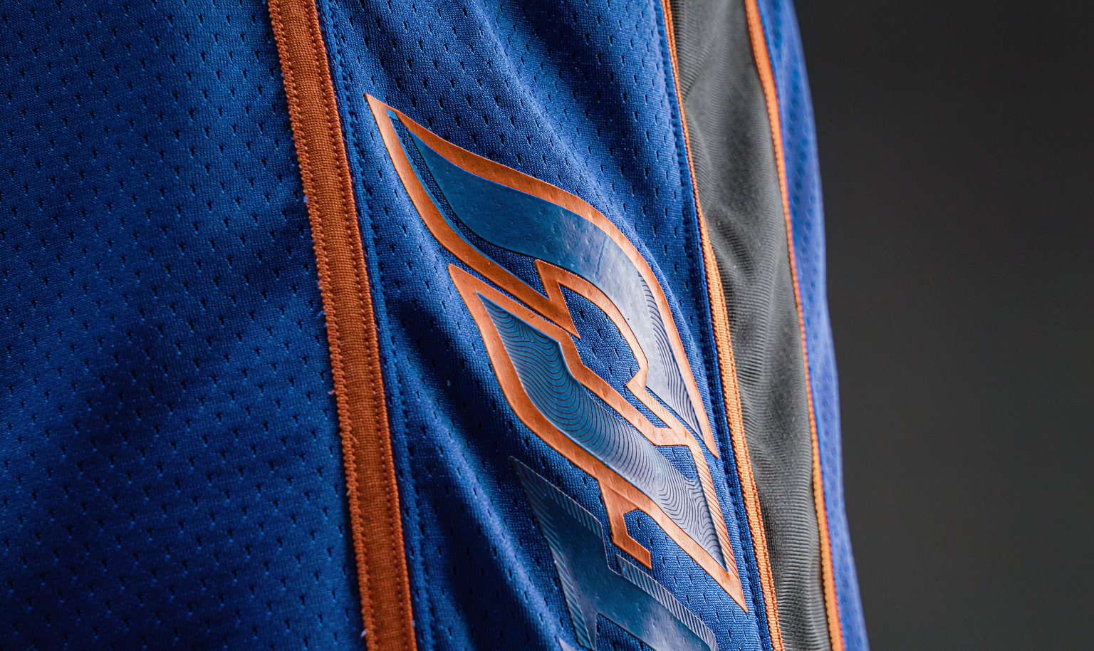 Heat-pressed name and number on a blue swingman basketball jersey - macro detail