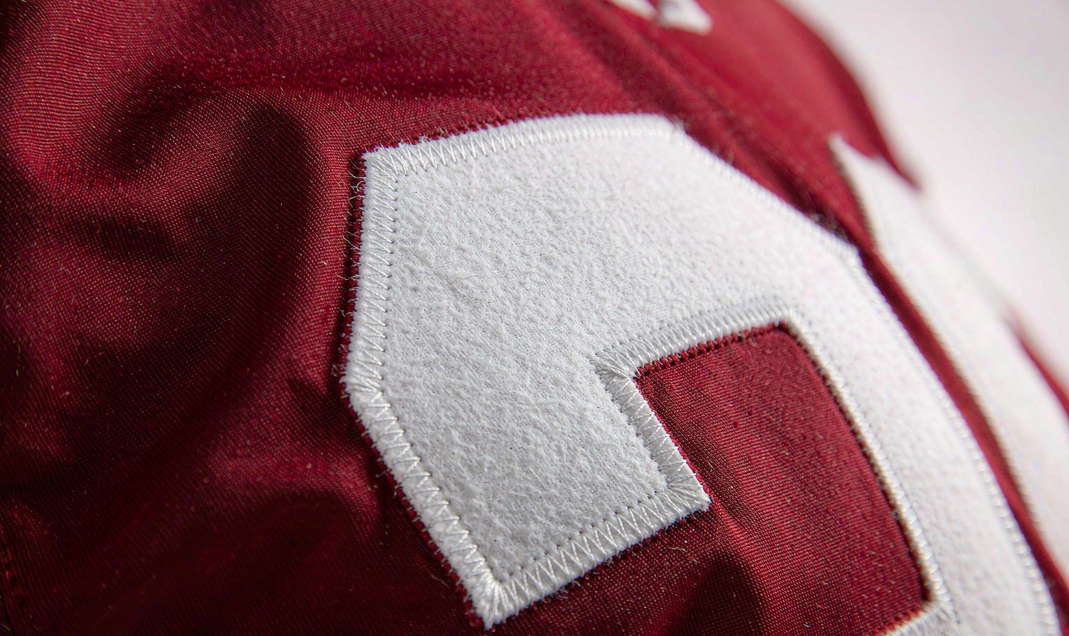Stitched tackle-twill letters and numbers on a college football jersey - macro detail