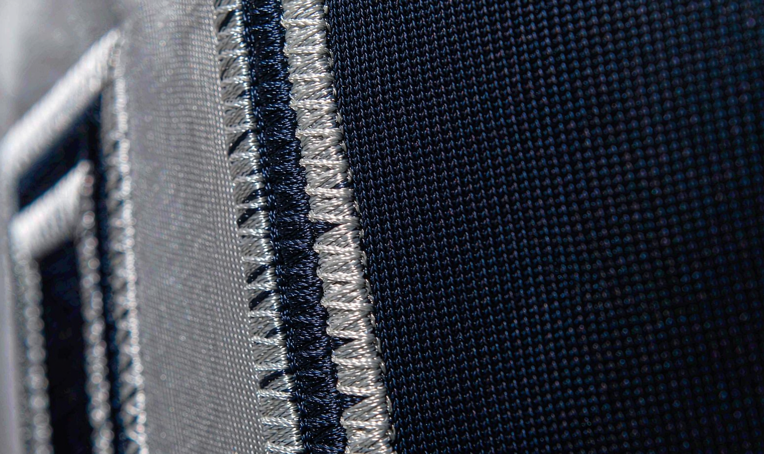 Stitched tackle-twill numbers on a navy NFL jersey - macro detail