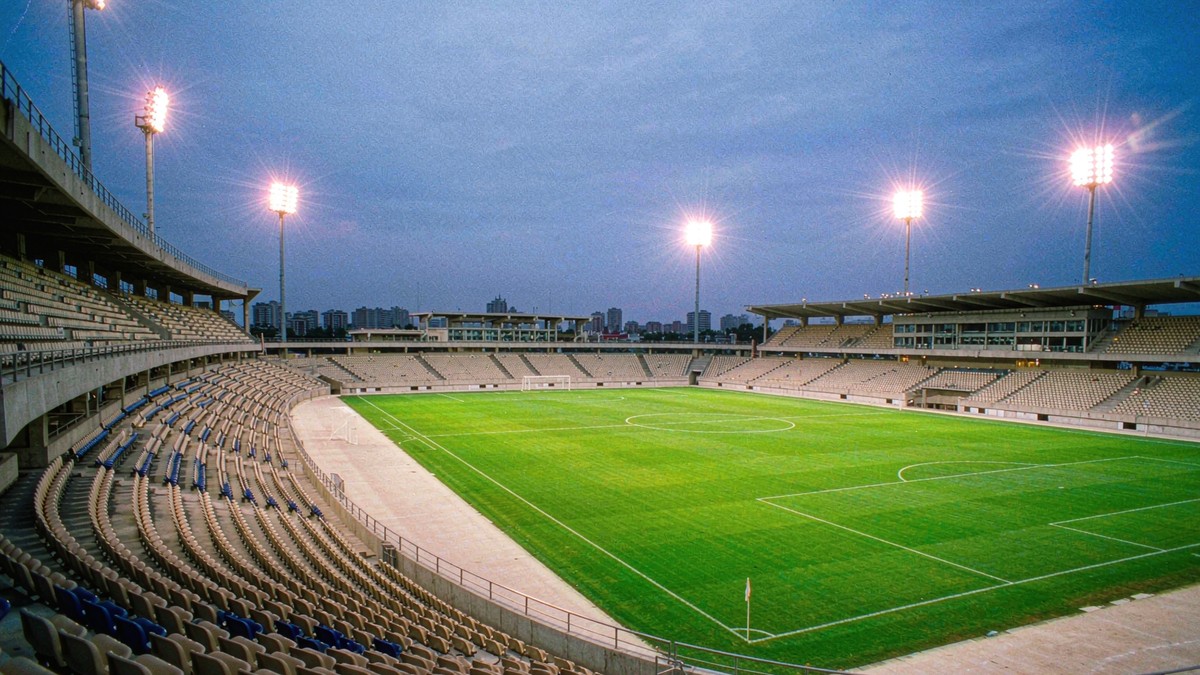 A floodlit international football stadium at dusk