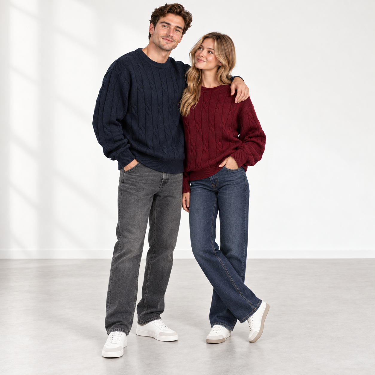Male and female models wearing Navy and Burgundy cable-knit sweaters in a clean studio
