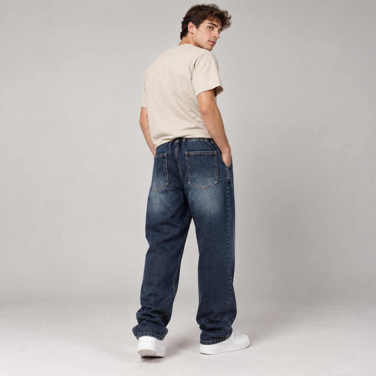 Male model wearing Dark Indigo relaxed drawstring baggy jeans, three-quarter back fit
