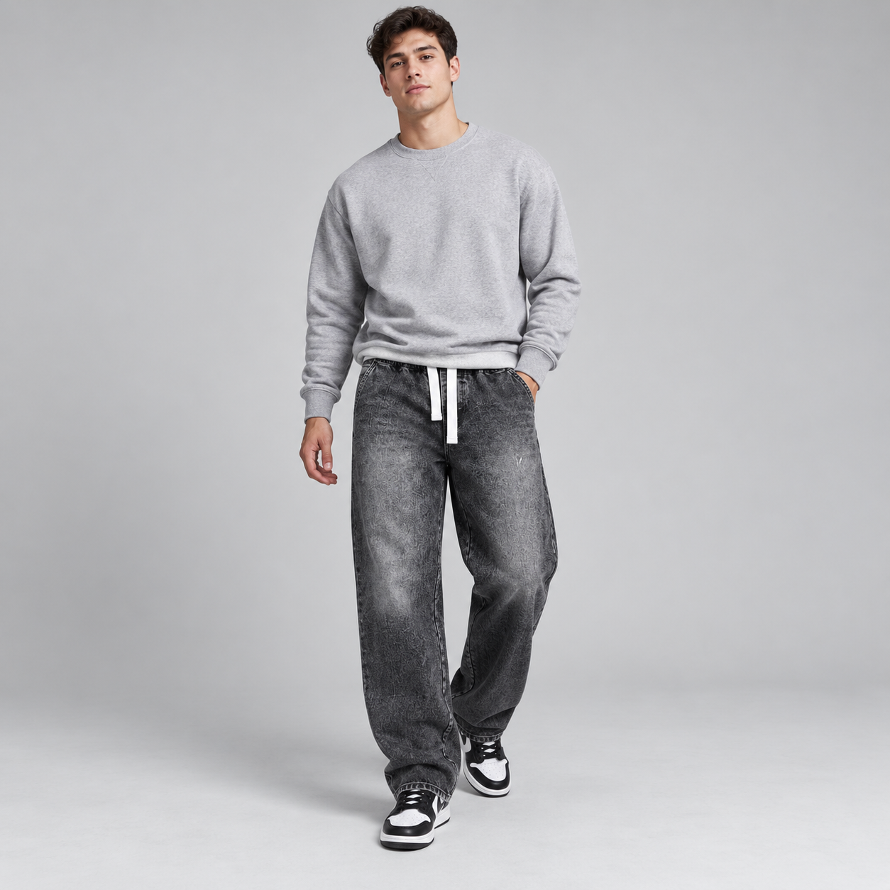 Male model wearing Washed Black relaxed drawstring baggy jeans, natural front pose