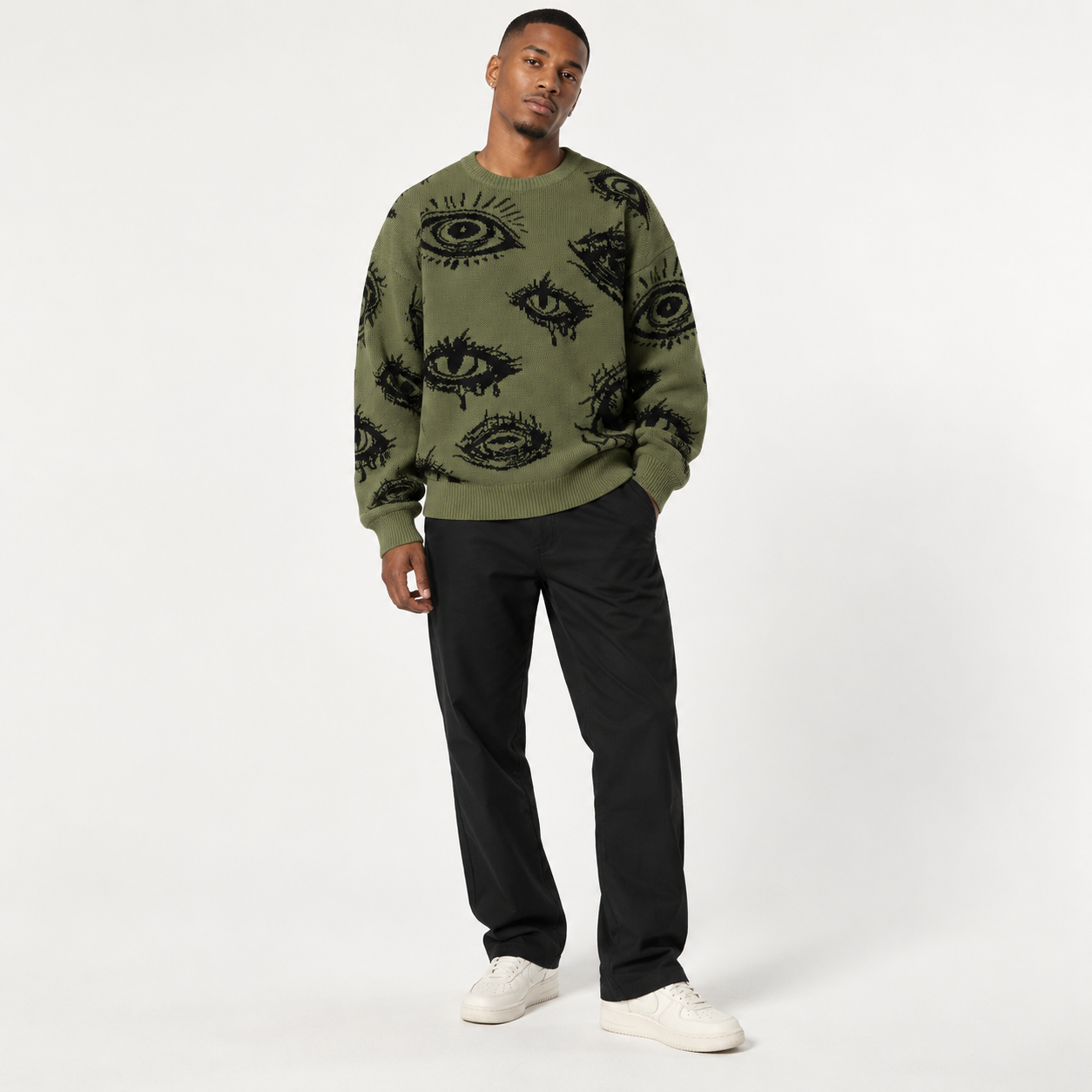 Young male model wearing Olive Green eye graphic sweater in a clean studio, natural pose