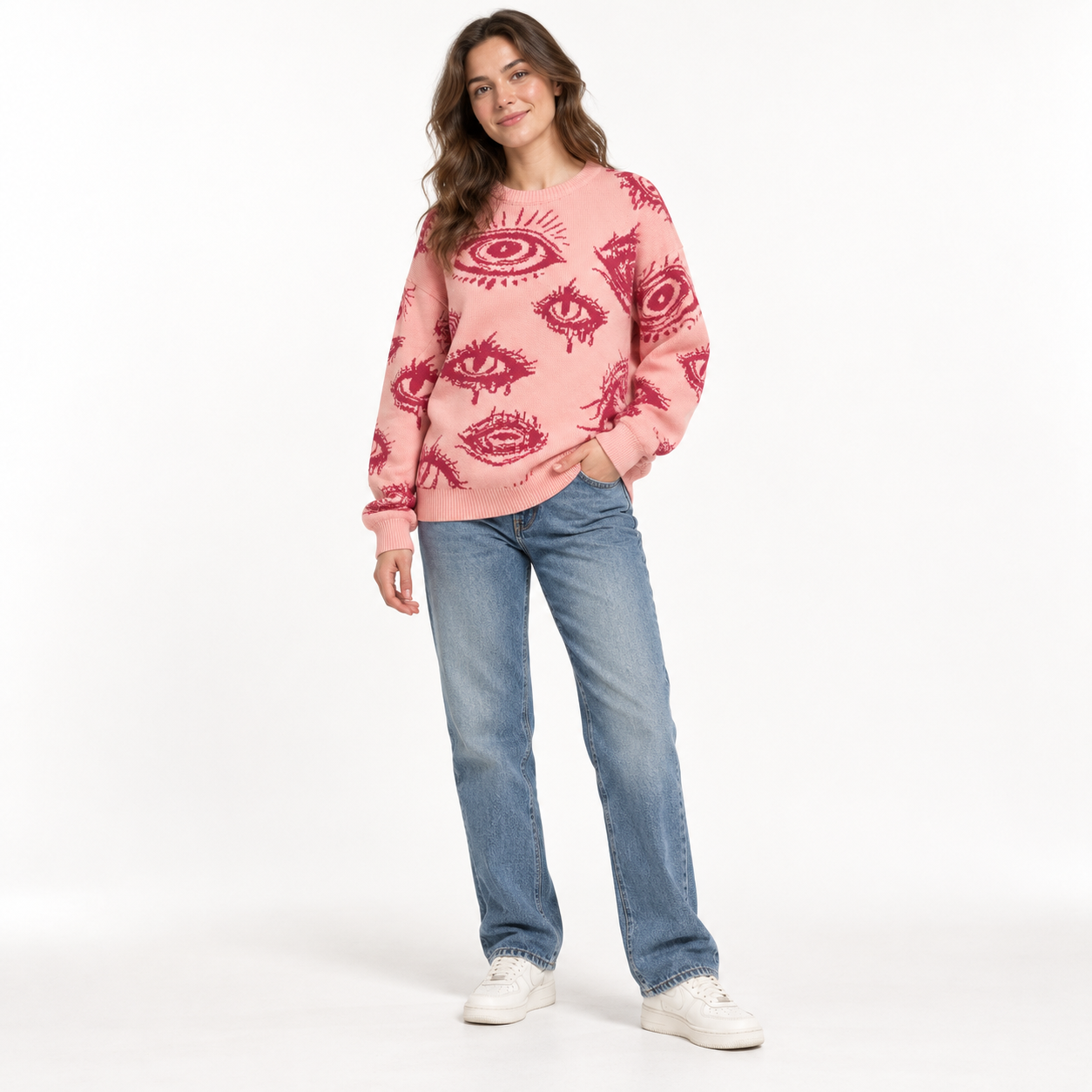 Young female model wearing Peach Pink eye graphic sweater in a clean studio, front view
