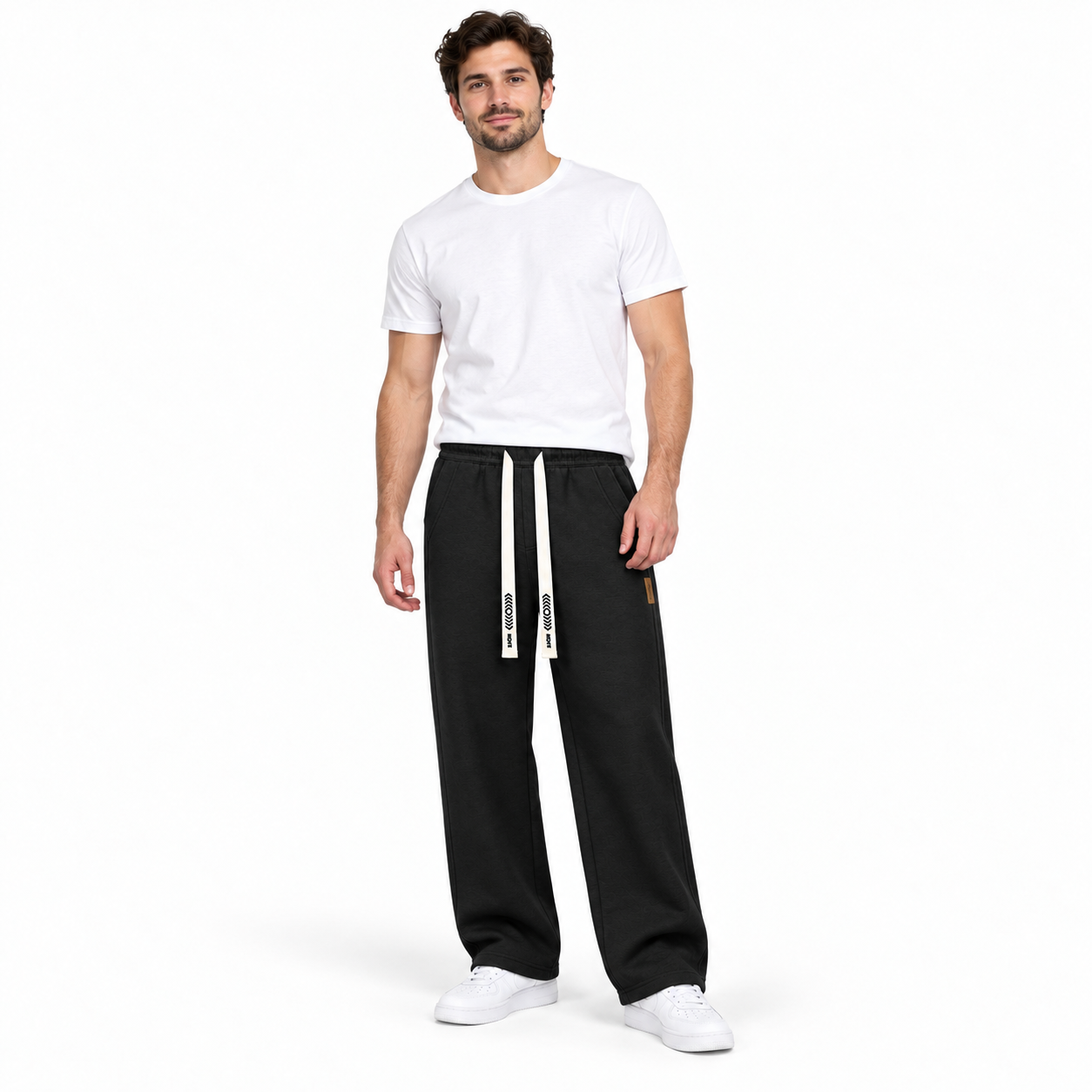 Man wearing Black heavyweight loose straight-leg drawstring pants, studio front view