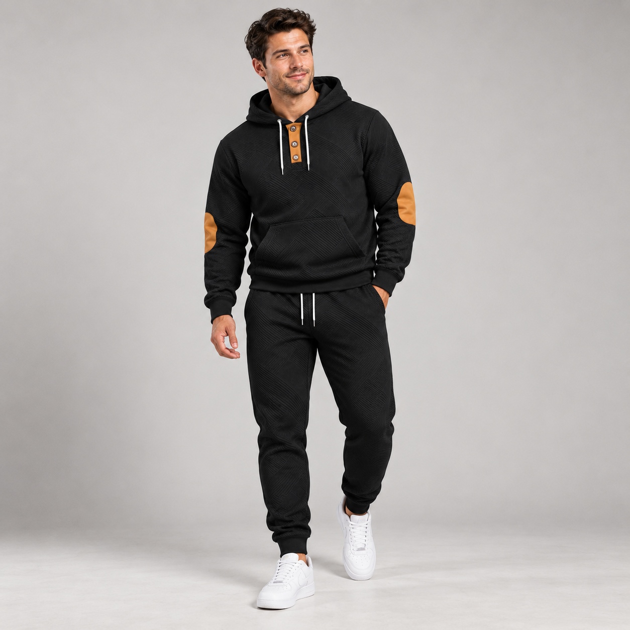 Model wearing the black textured two-piece hoodie and jogger tracksuit in a full-body studio view