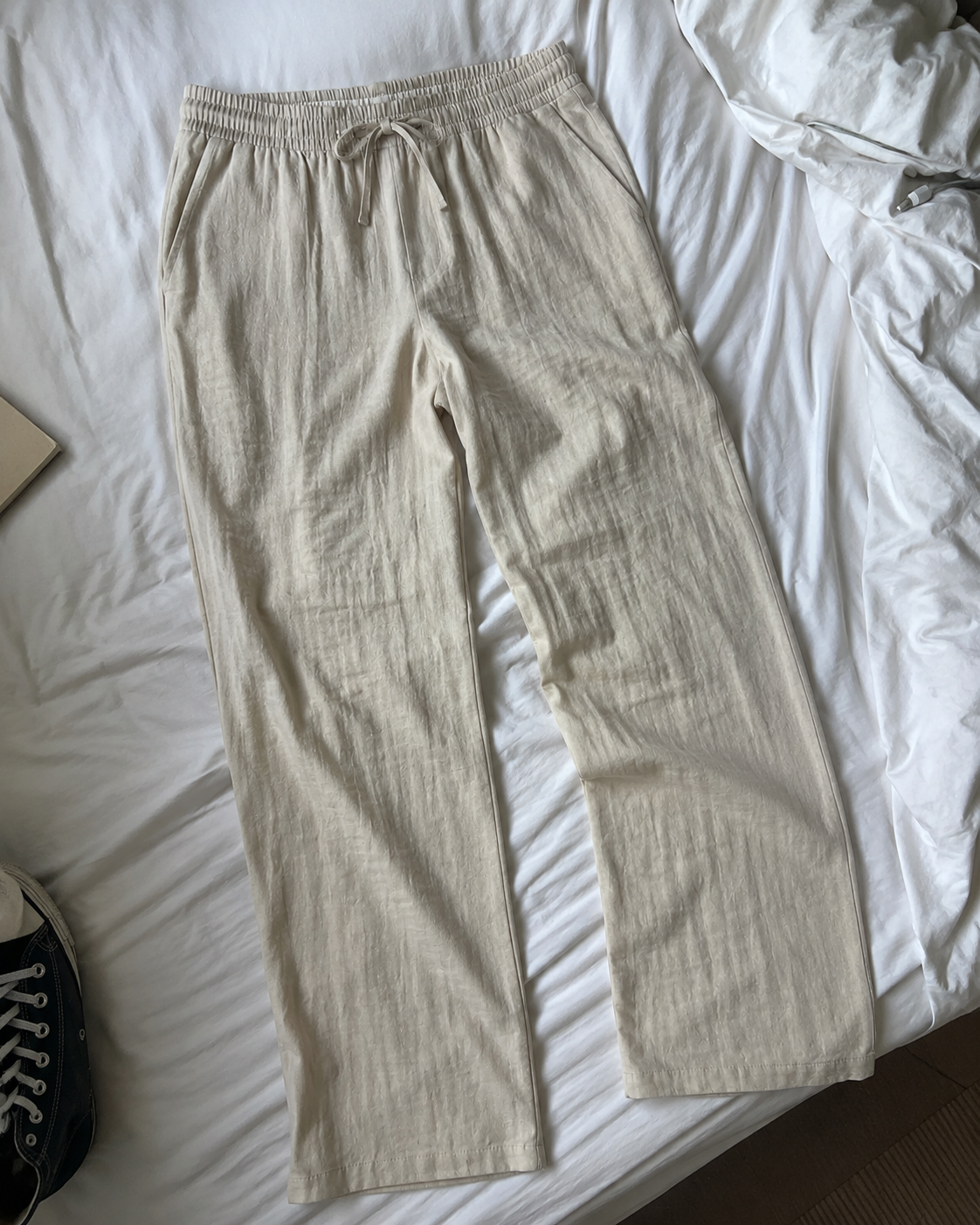 Sand beige linen-blend pants arranged in a casual flat-lay