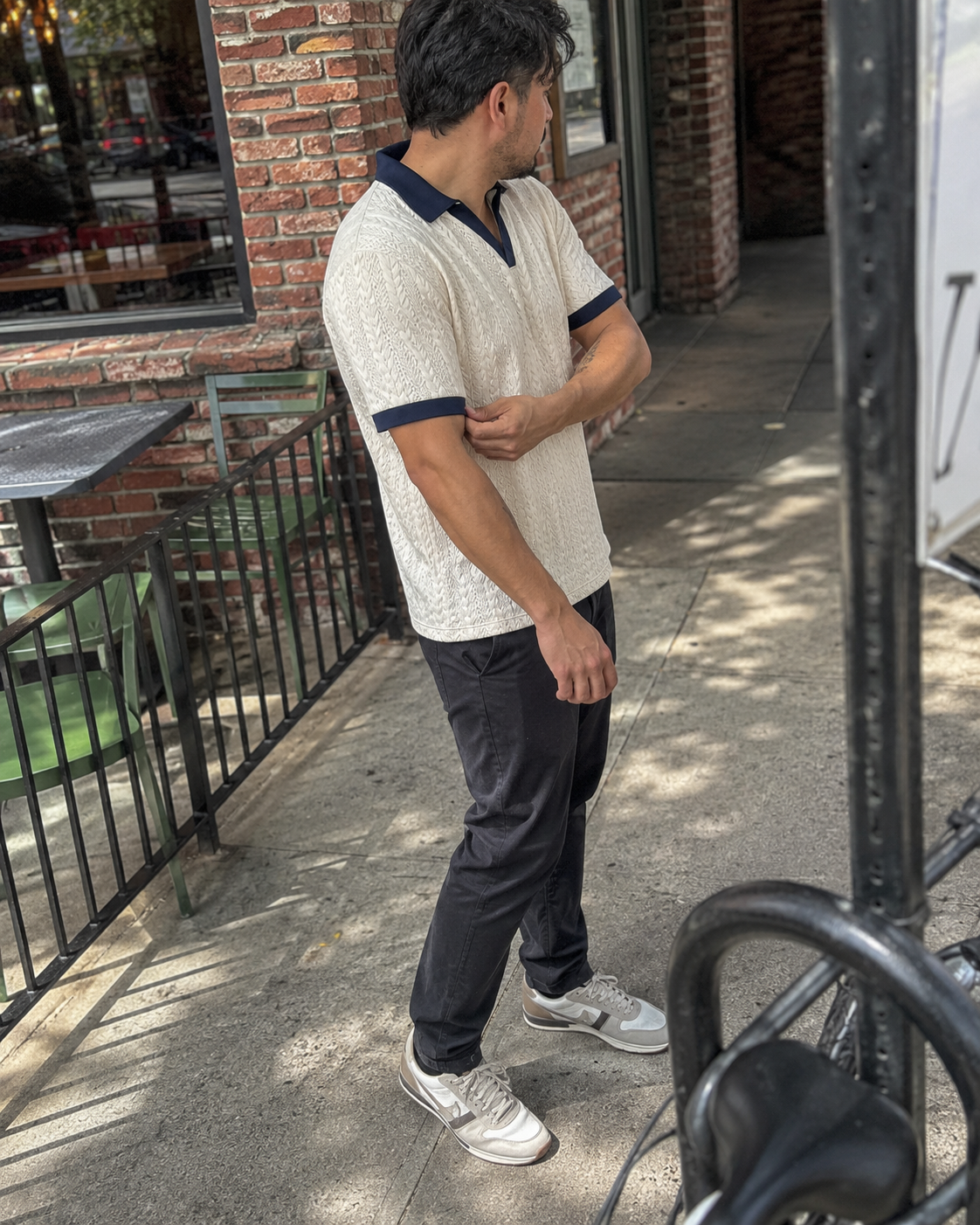 Ivory open-collar polo with navy trim in a candid street scene