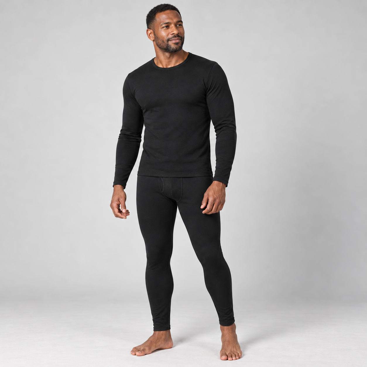 Black fleece-lined thermal underwear set on a male model in a clean studio, front three-quarter view