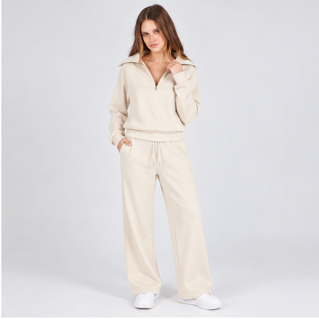 Woman wearing the Ivory Cream half-zip top and wide-leg pants set, studio front view