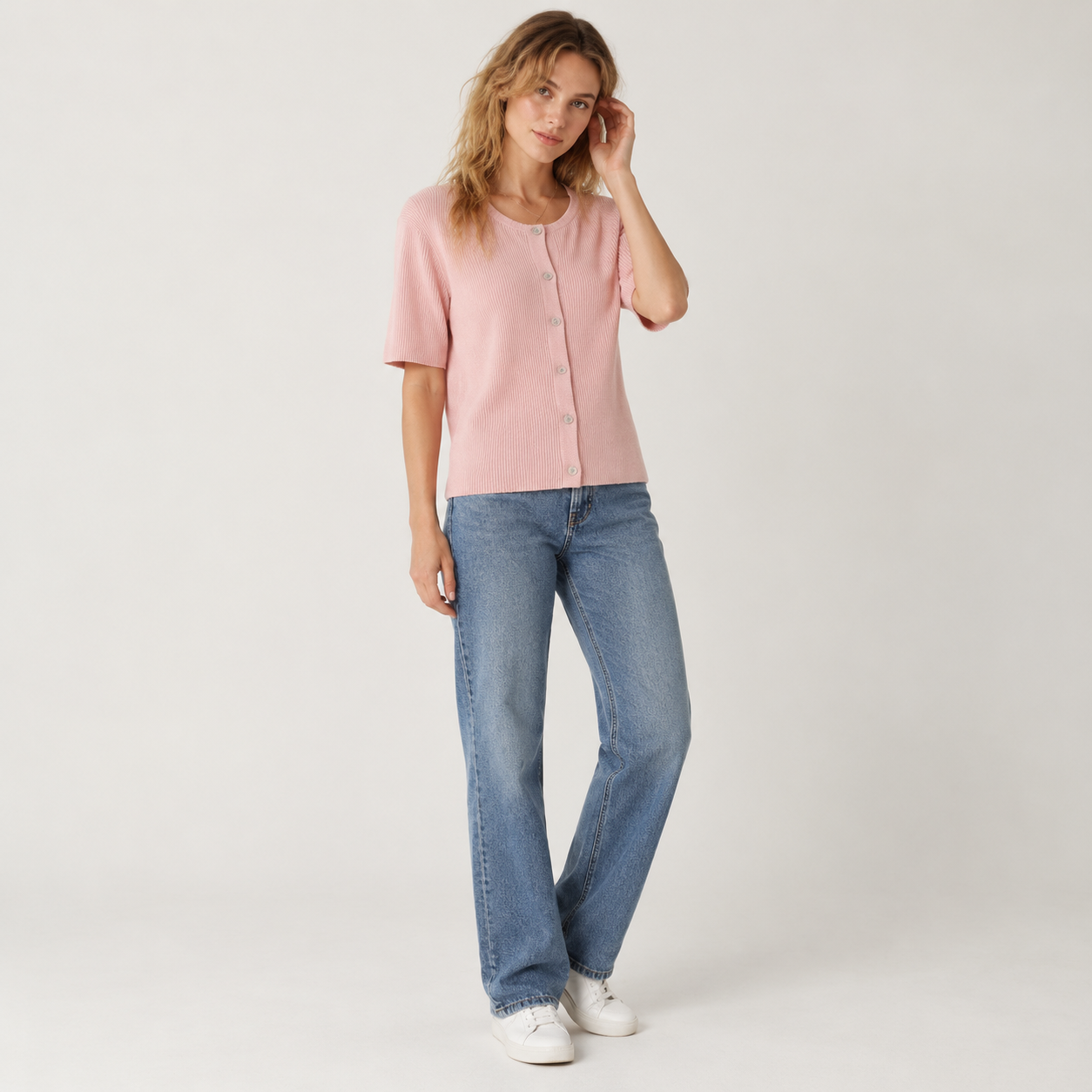 Woman wearing the Soft Pink short-sleeve ribbed cardigan buttoned, studio front view